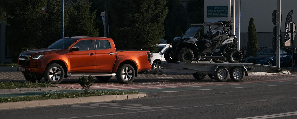 Pick-up qui tire un côte à côte sur une remorque double essieu